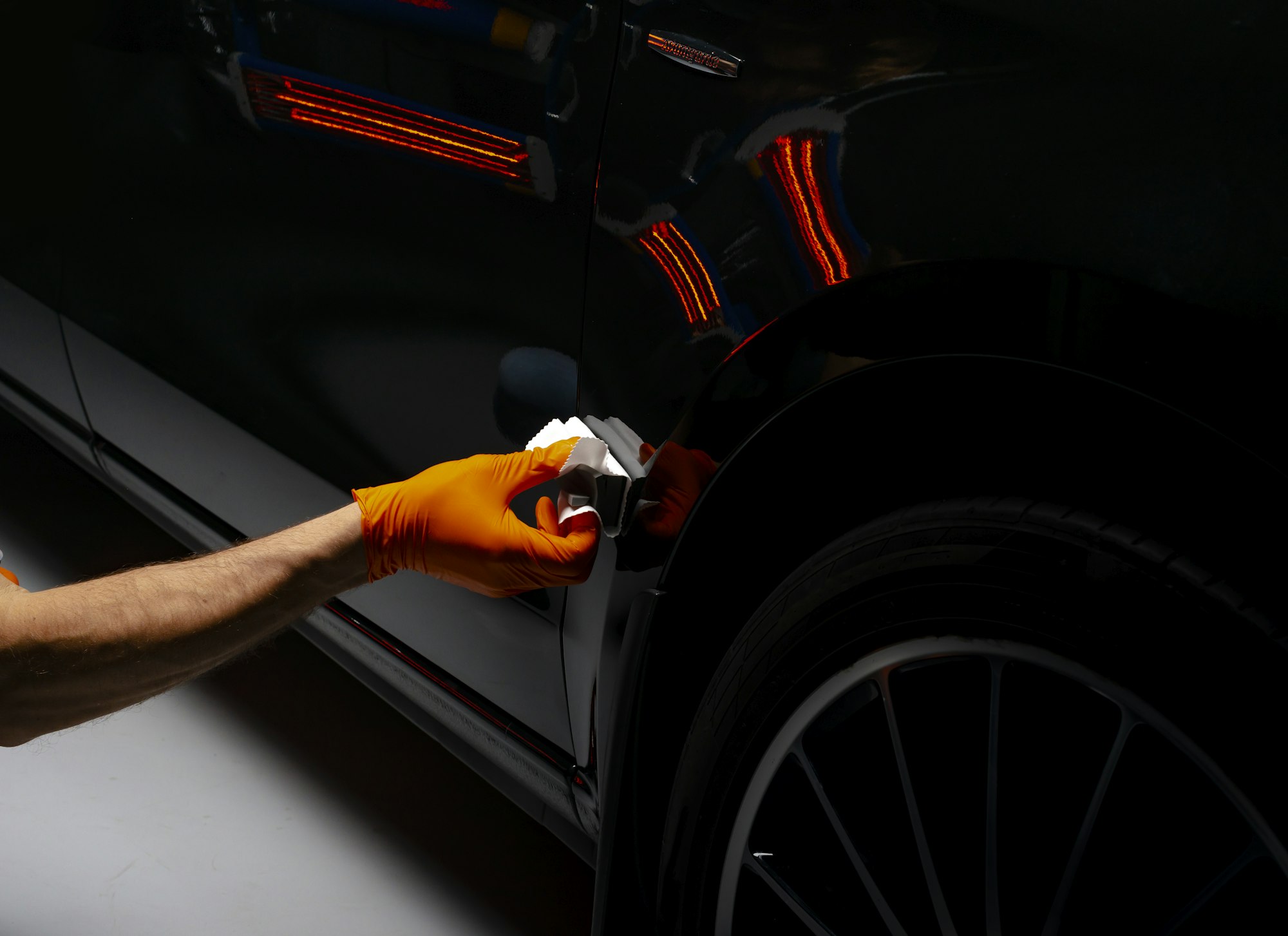 Car polish wax worker hands polishing car